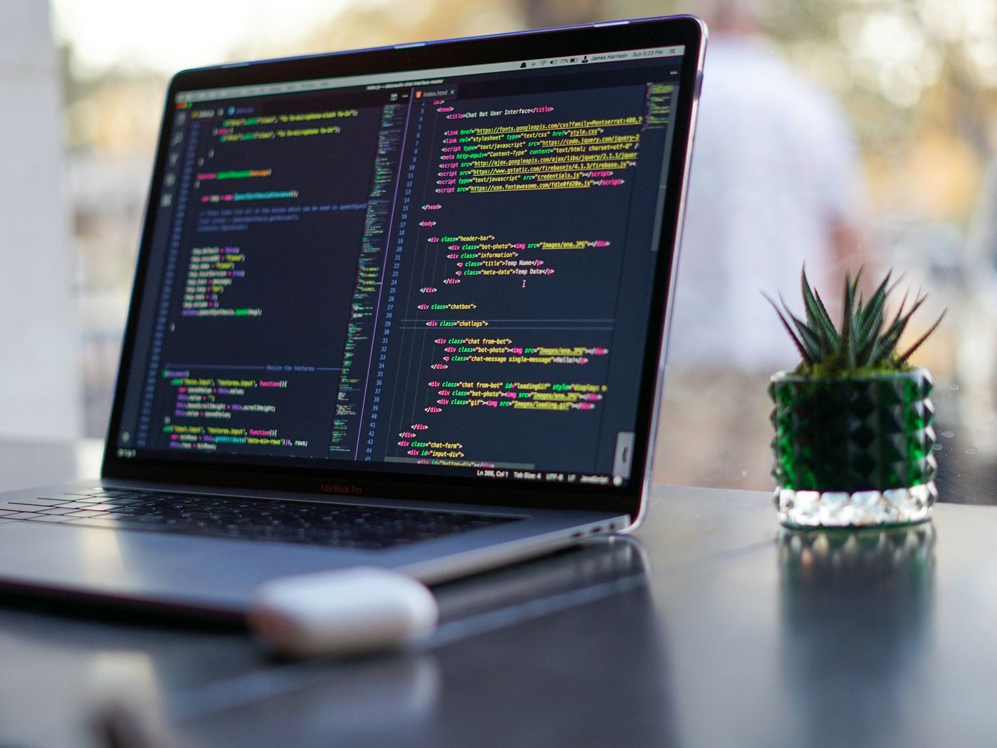 A code editor open on a laptop at a desk