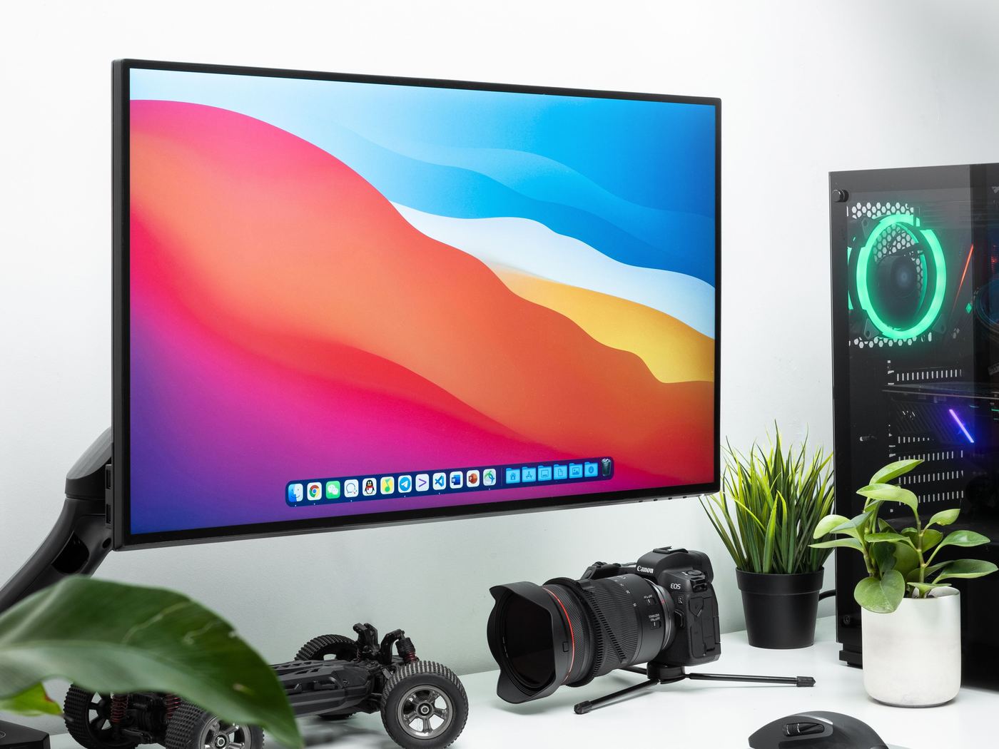 A desk with a monitor, tower and camera set up and ready